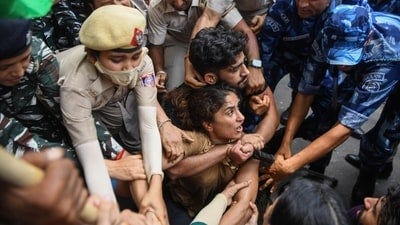 Police and Paramilitary personnel detain wrestler Vinesh Phogat during the protest march from Jantar Mantar to New Parliament House against the alleged sexual harassment of women wrestlers by WFI chief Brij Bhushan Sharan Singh, in New Delhi on Sunday. (ANI Photo/Amit Sharma) (Amit Sharma)