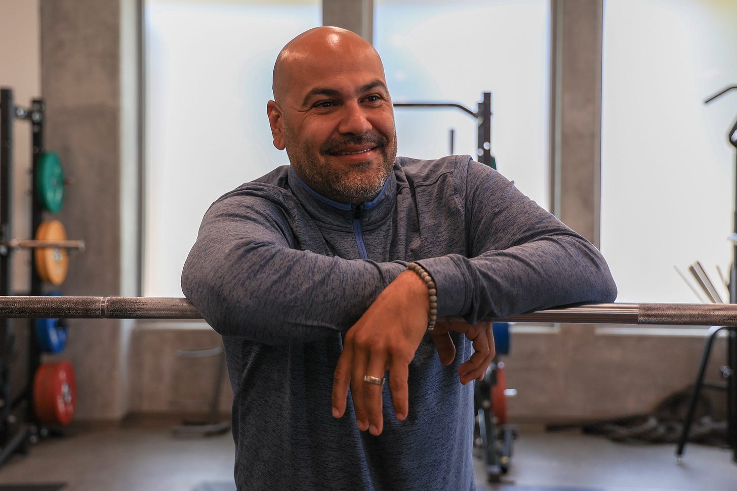 CJ Arnold, El Camino College athletics specialist, leans on a weightlifting bar in the weight room on Thursday, March 27. Arnold was hired as the athletic specialist in 2021. He helps ensure ECC student-athletes maintain their eligibility to participate in sports by having the required GPA. Arnold also helps work on the budget for the ECC athletics department. (Eddy Cermeno | The Union)