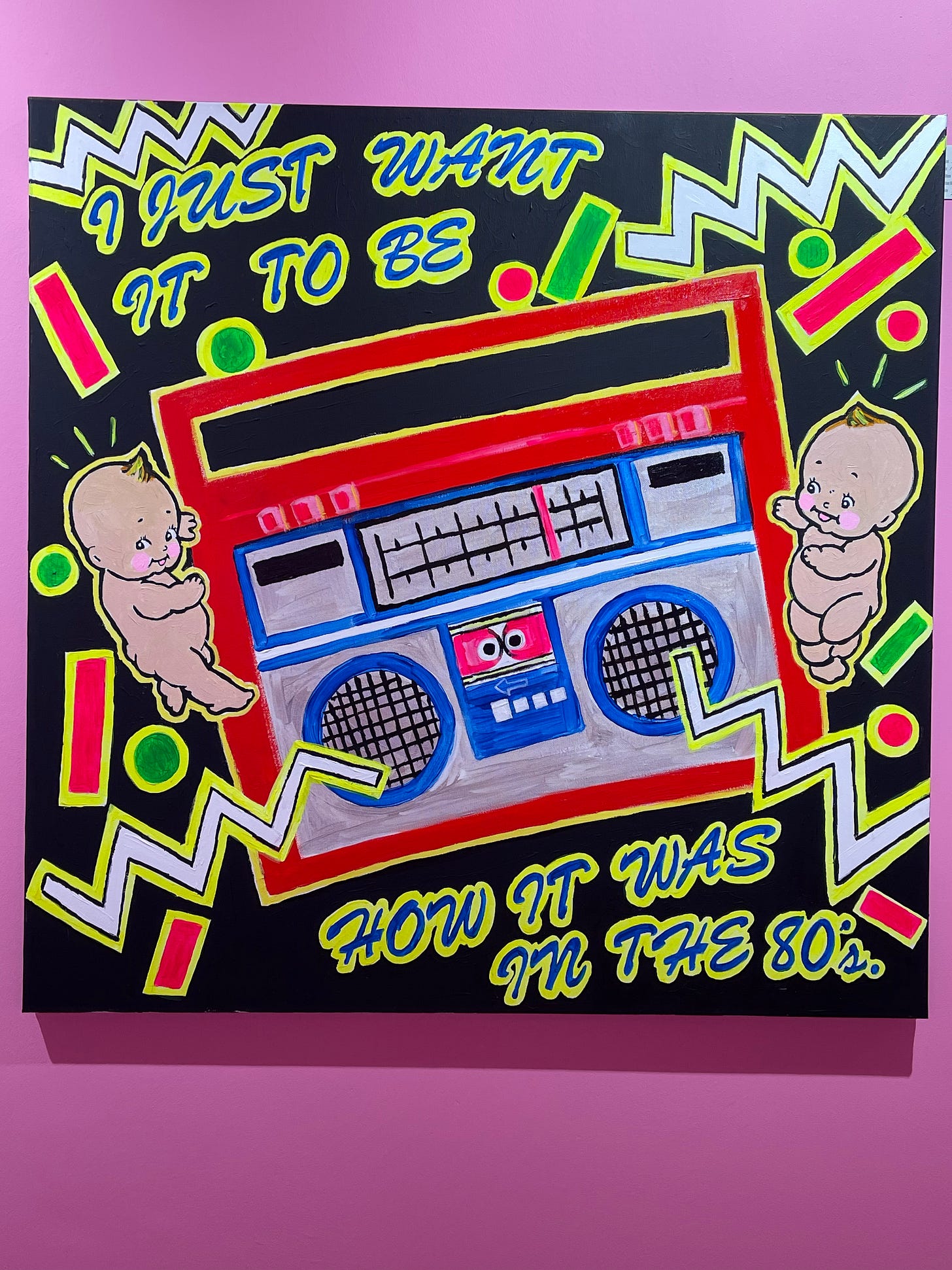 Art piece with an old stereo and writing saying 'I just want it to be how it was in the 80's'. Two punk babies on the side of the stereos