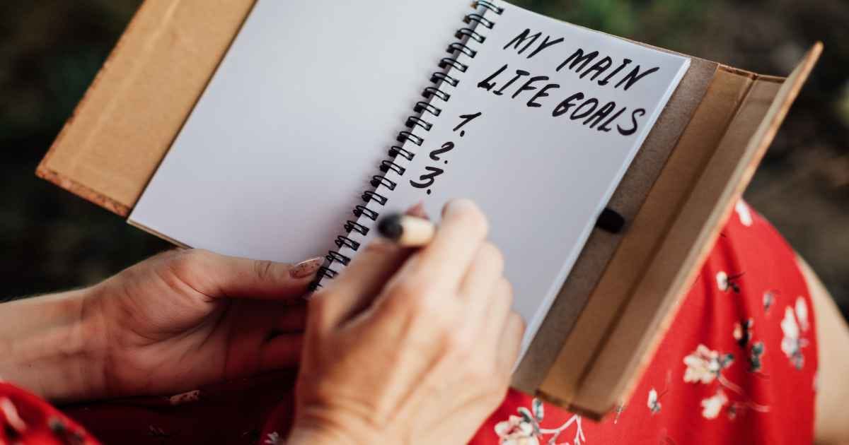 female hand writes in a notebook