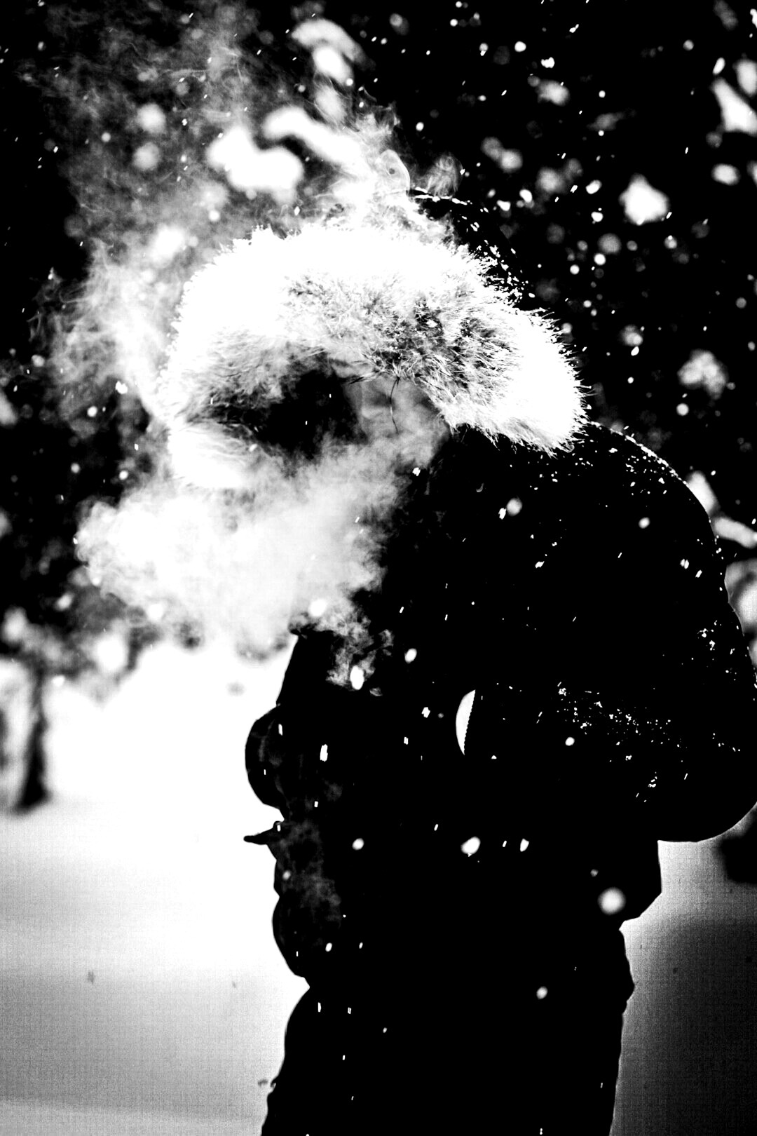 a person standing in the snow smoking a cigarette