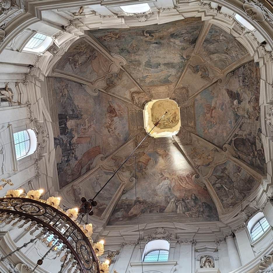 A ceiling with a chandelier and painting on it

AI-generated content may be incorrect.