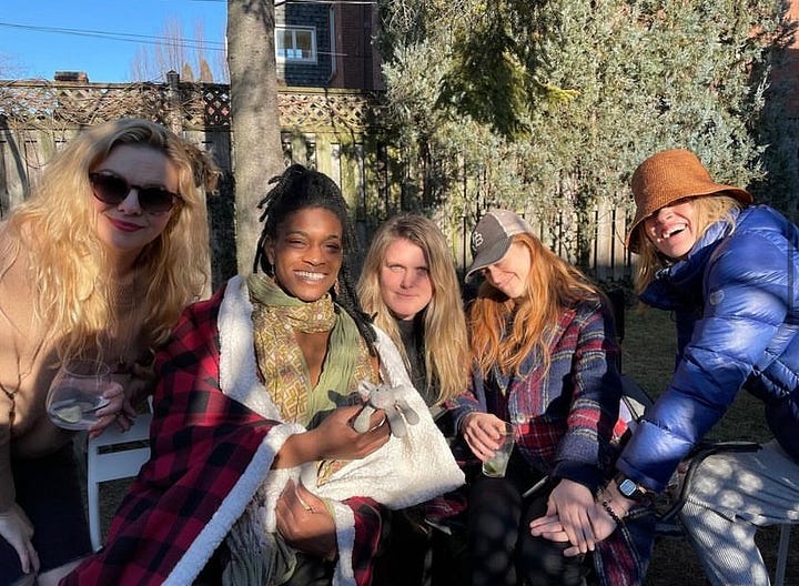 Five photos. Clockwise from top left: 1. Amber and Eliza take a selfie together outside. They both are laughing and wearing sunglasses. 2. In the foreground, Eliza gives a model look to the camera. In the background, Amber photobombs the picture, making a funny face. 3. Amber behind the scenes on the set of "Y: The Last Man." She stands staring into the camera with a large group of women behind her, also staring into camera. They all wear facemasks. 4. Amber, Ashley Romans, Eliza Clark, Marin Ireland, and Missi Pyle sit outside in the sun. They are all wearing big coats/hats/scarves and smile into camera. 5. Amber and Eliza stand chest-deep in the ocean facing each other. They are both laughing with their heads thrown back, not looking at the camera. They both wear sunglasses.