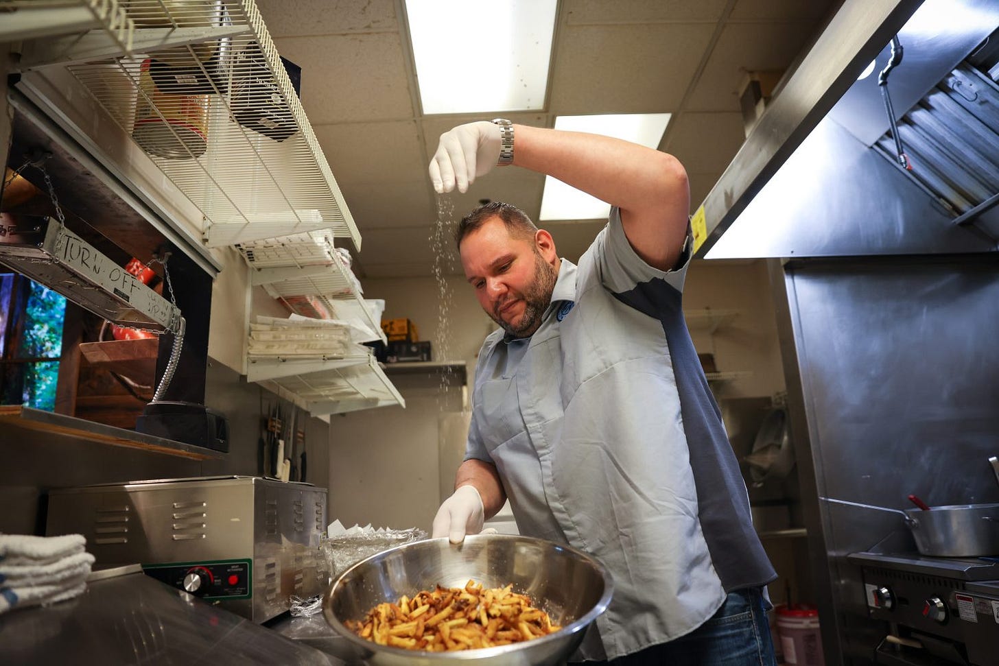 man cooking french fries in a kitchen man cooking french fries in a kitchen