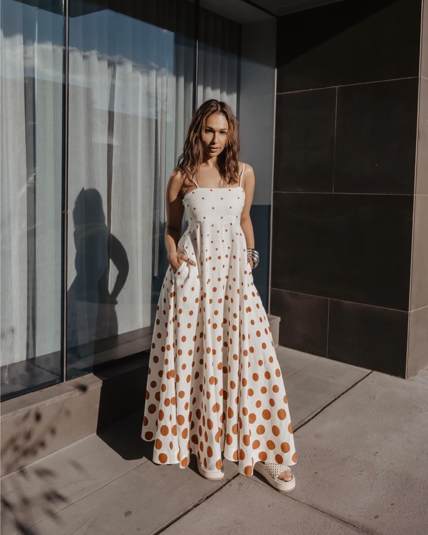 Sharon Johal in a white dress with brown polka dots