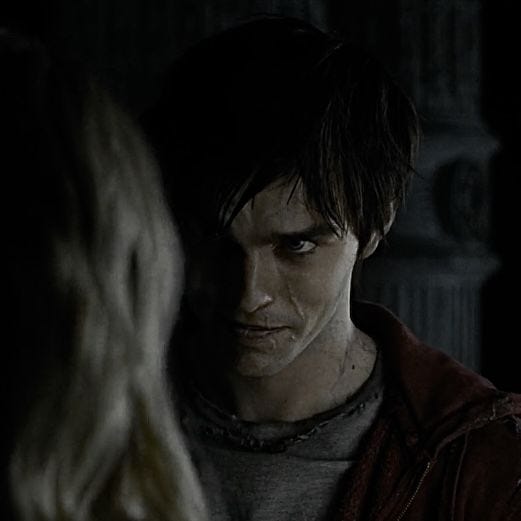 This may contain: a young man standing next to a woman in a dark room with the light on