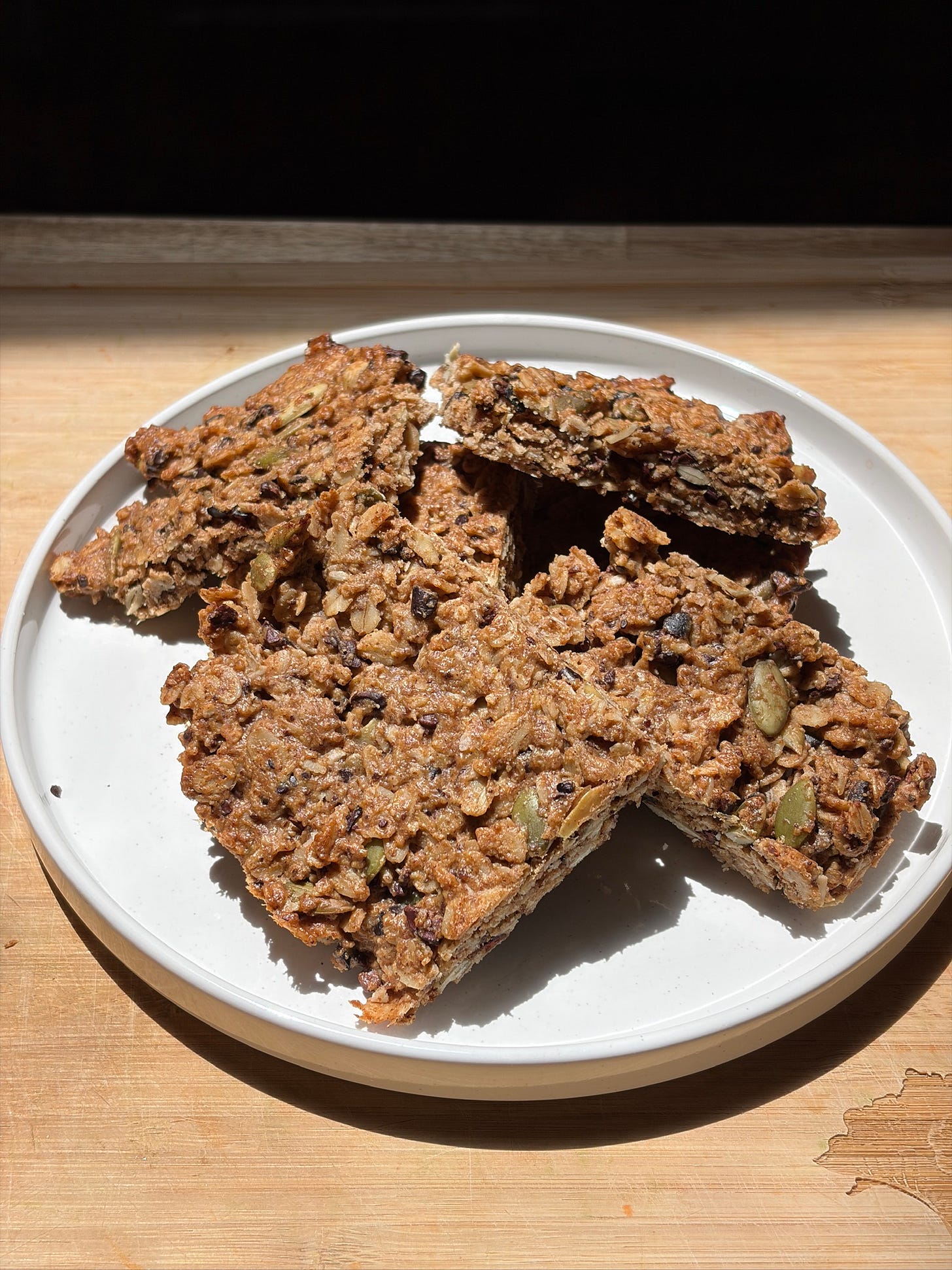 Close-up of a gluten-free almond butter cacao nib granola bar showing oats, pumpkin seeds, and cacao nibs Close-up of a gluten-free almond butter cacao nib granola bar showing oats, pumpkin seeds, and cacao nibs