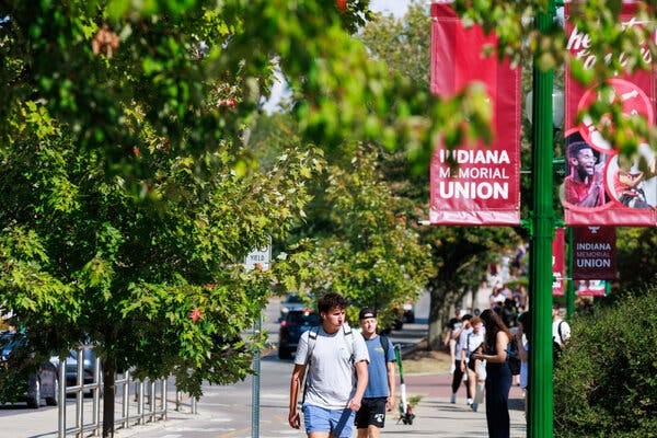 Several people walk along a leafy path on Indiana University Bloomington’s campus. Several people walk along a leafy path on Indiana University Bloomington’s campus.
