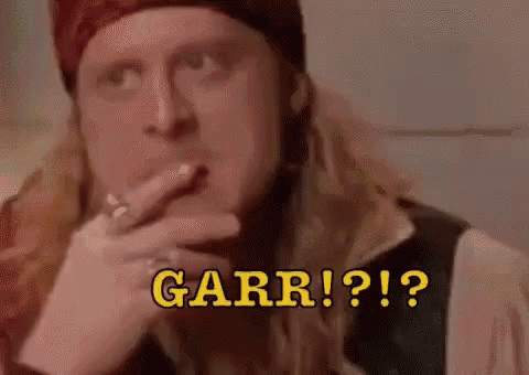 a man with long hair is smoking a cigarette and says garr !