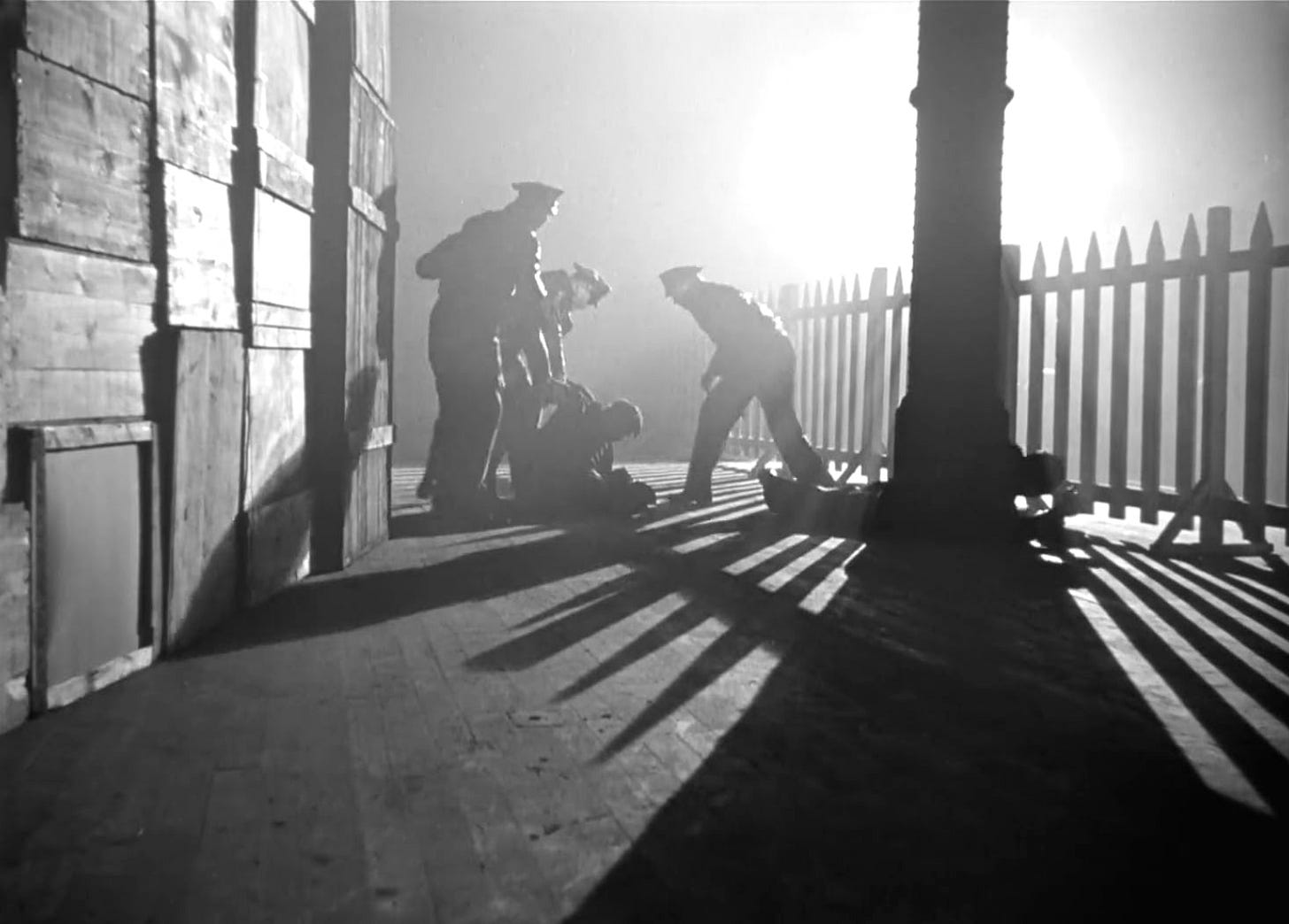 Three men beat a fourth in the spotlit darkness in "The Long Voyage Home" (1940)
