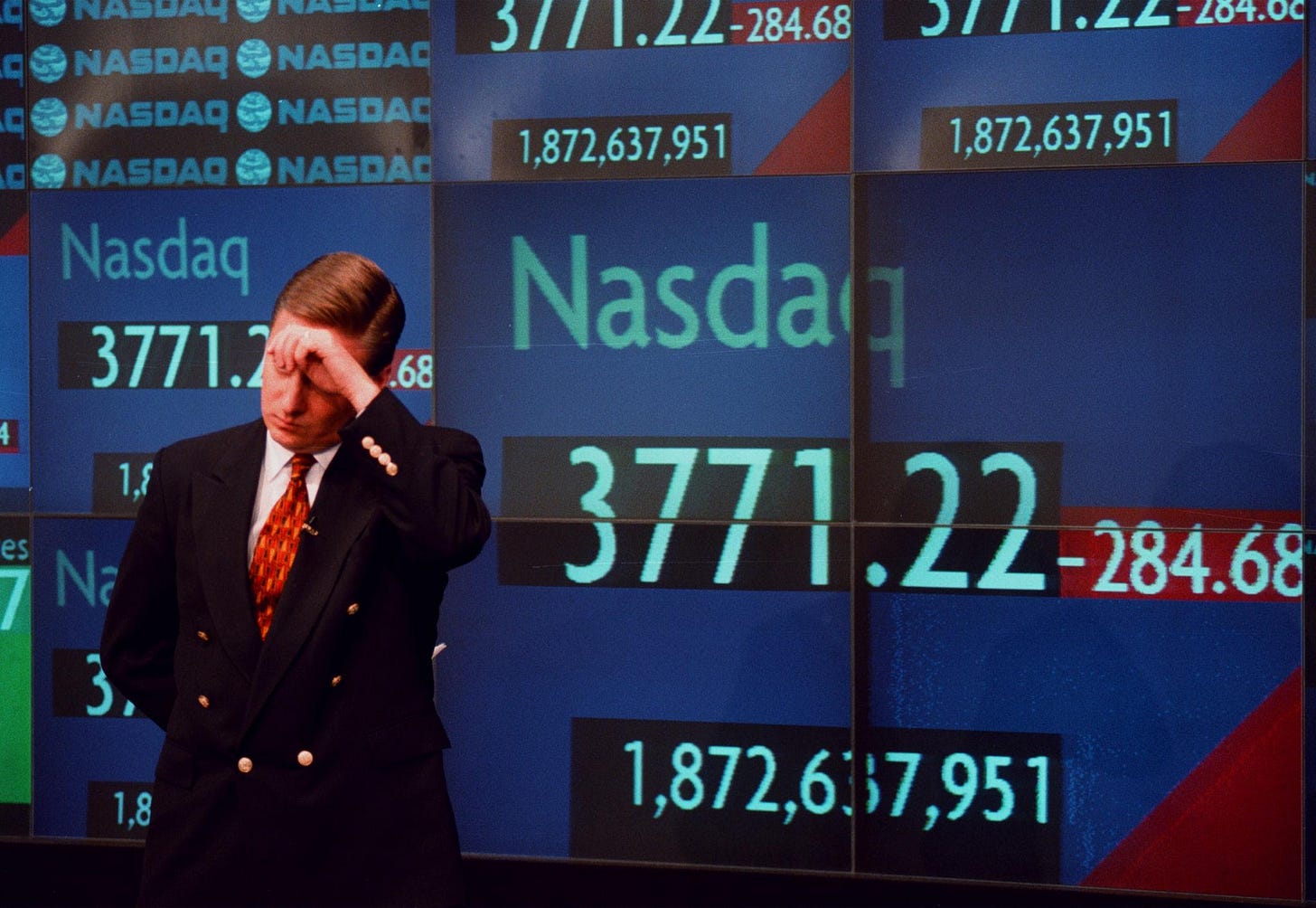 Authentic April 2000 photograph by Chris Hondros of CNBC correspondent Tom Costello wiping his brow in front of the Nasdaq MarketSite boards after a sharp market decline. Authentic April 2000 photograph by Chris Hondros of CNBC correspondent Tom Costello wiping his brow in front of the Nasdaq MarketSite boards after a sharp market decline.