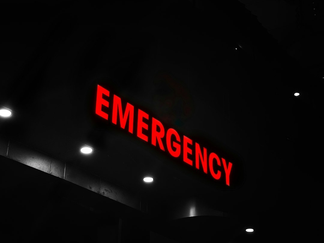 Red emergency sign illuminates a dark building entrance.