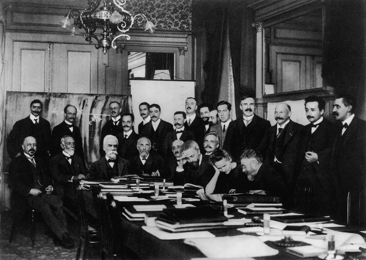 Marie is seated at the table just to the right. Einstein is second from the right.