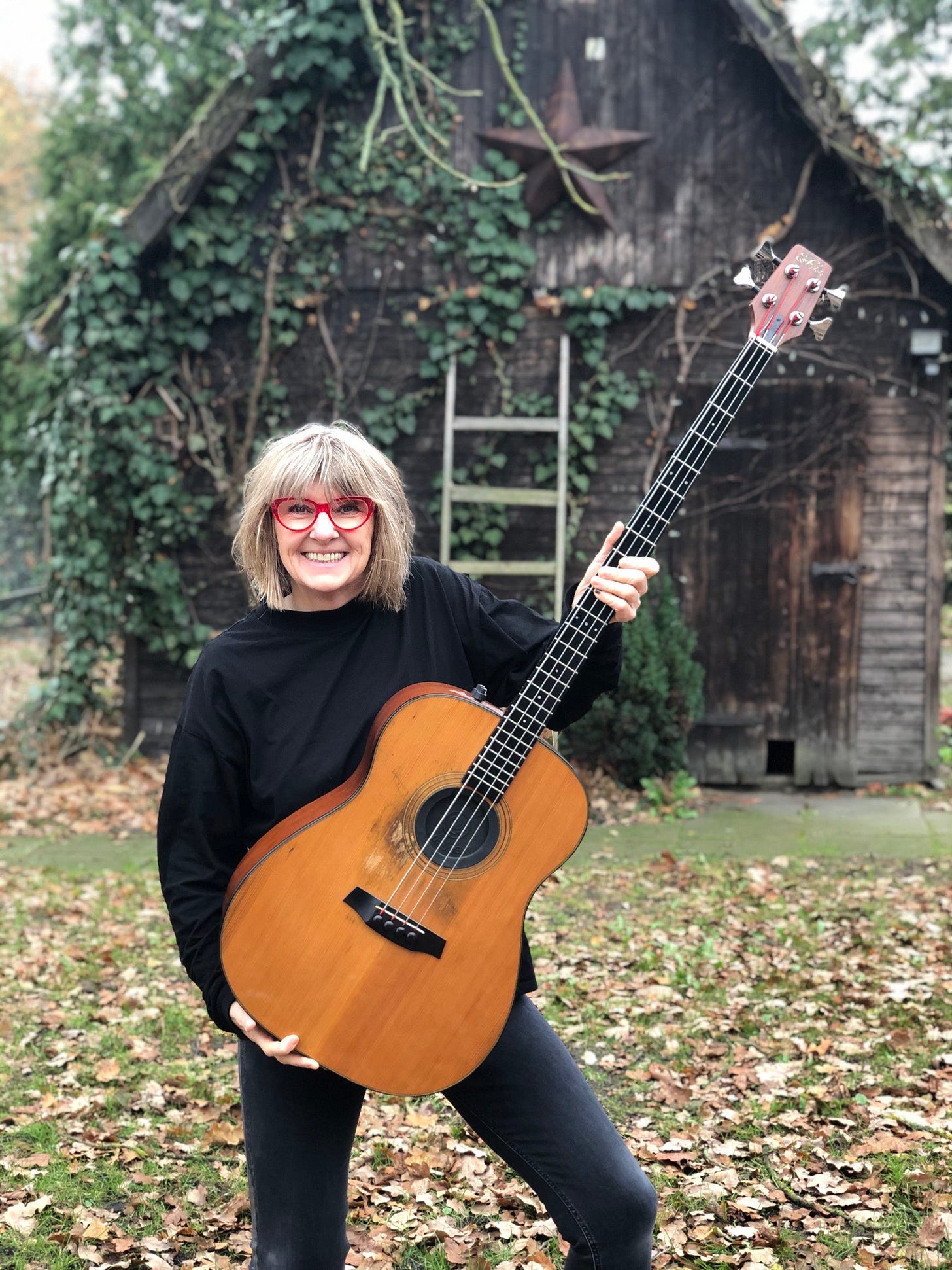 Suzy Starlite with her Fylde King John bass pictured in front of a wooden shed in Winsen Aller, Germany 