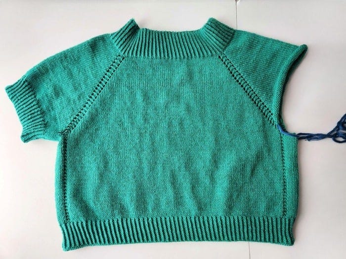 One sleeve completed with twisted rib for the short sleeve cuff.