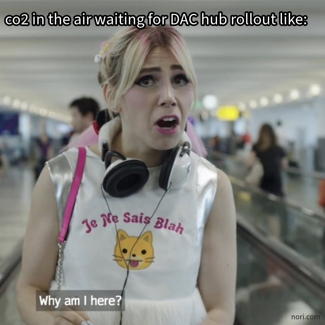 A young woman in an airport wearing headphones and a cat T-shirt, captioned "co2 in the air waiting for DAC hub rollout like:" and "Why am I here?"