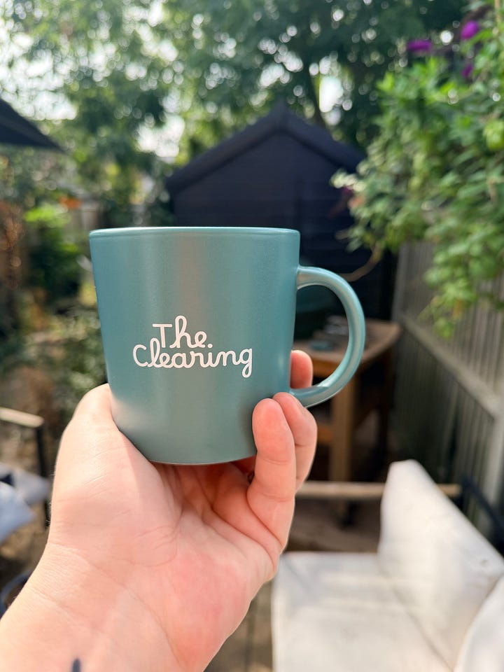 A teal mug with a patchwork motif and the words' The Clearing' in white