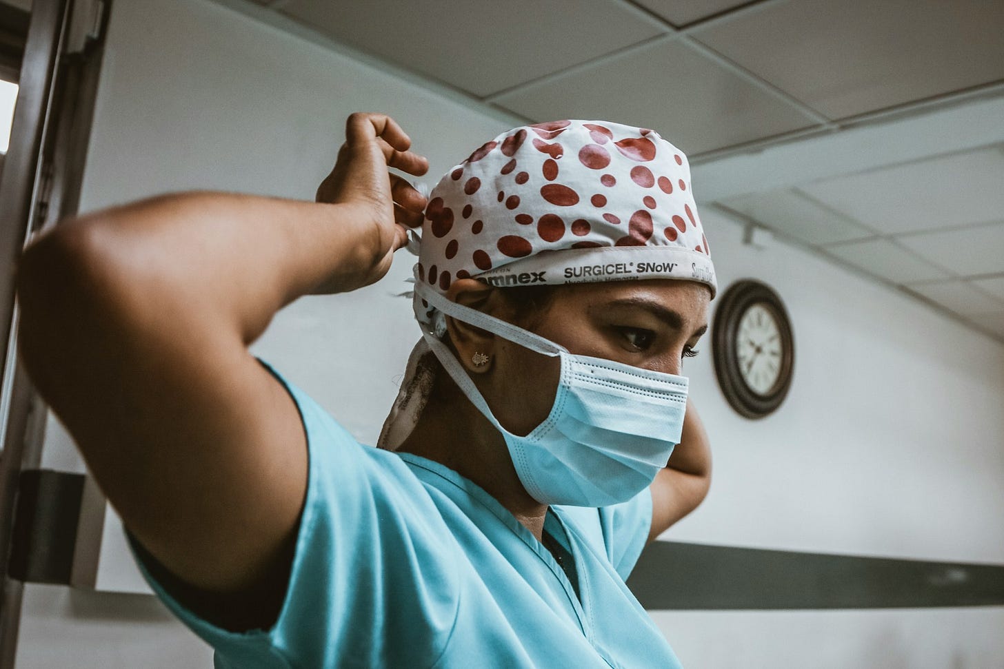 Healthcare worker adjusts a face mask before a shift, highlighting the demands of medical work and the importance of maintaining energy and resilience. Photo by SJ Objio on Unsplash