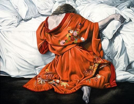 Woman sitting on the floor in an orange robe clings to a white bed piled with pillows and sheets Woman sitting on the floor in an orange robe clings to a white bed piled with pillows and sheets