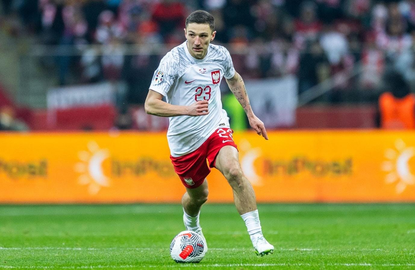 A person in a football uniform kicking a ball

Description automatically generated
