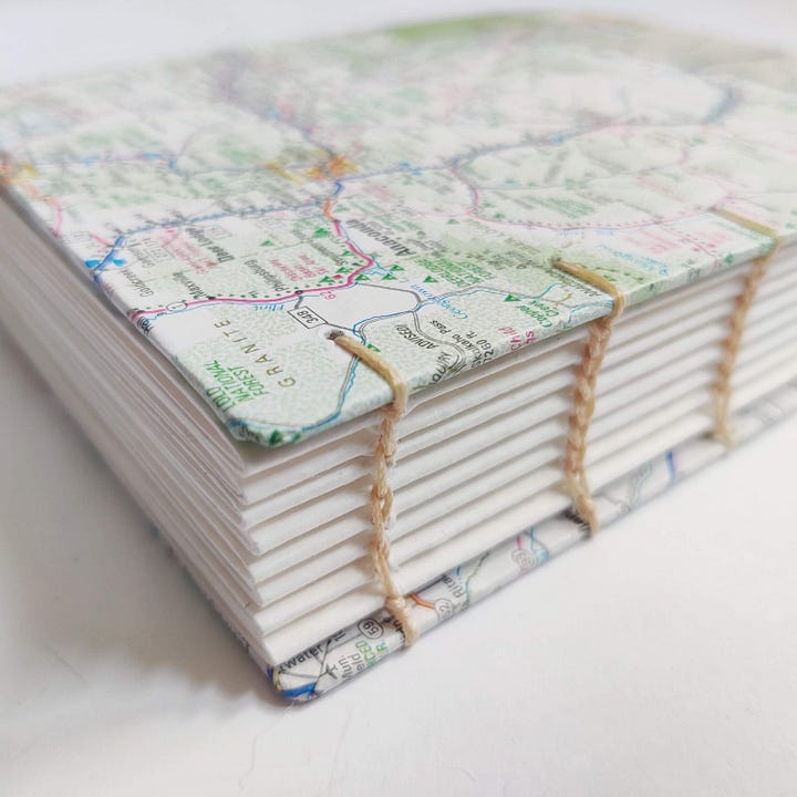 A newly bound art journal, with map covers and blank pages.