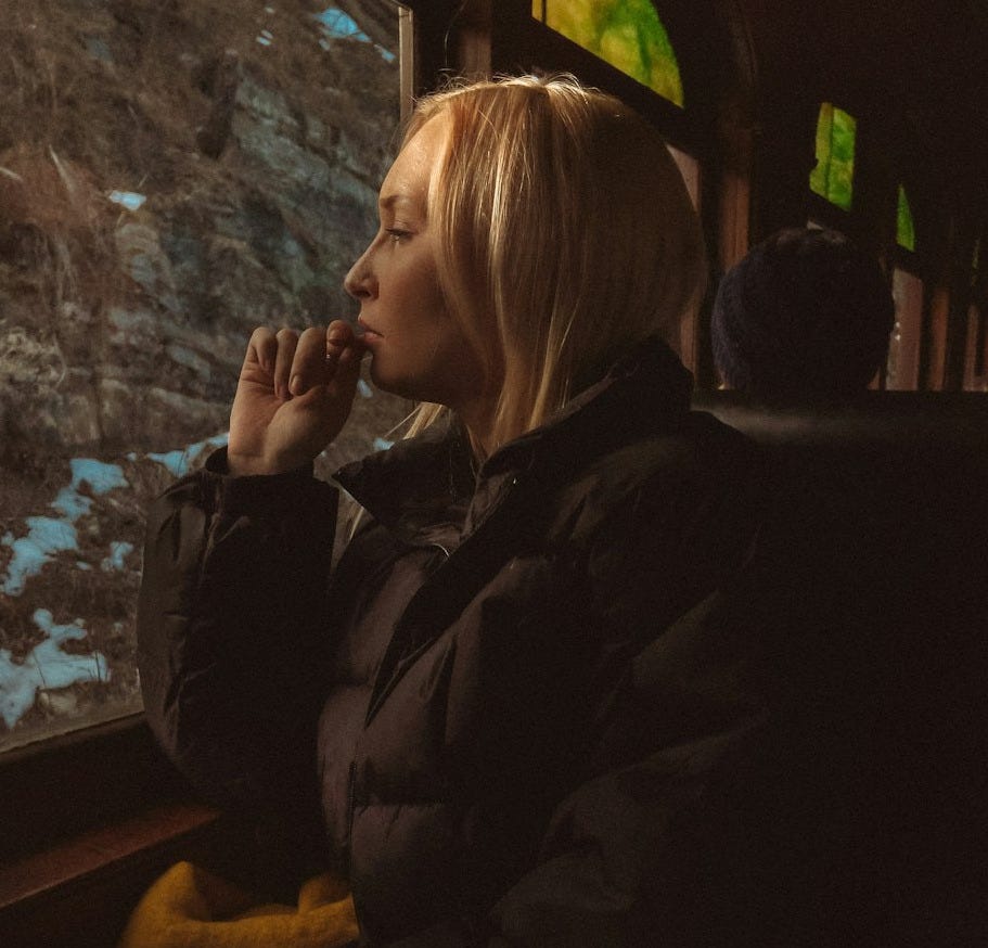 a woman sitting on a train looking out the window