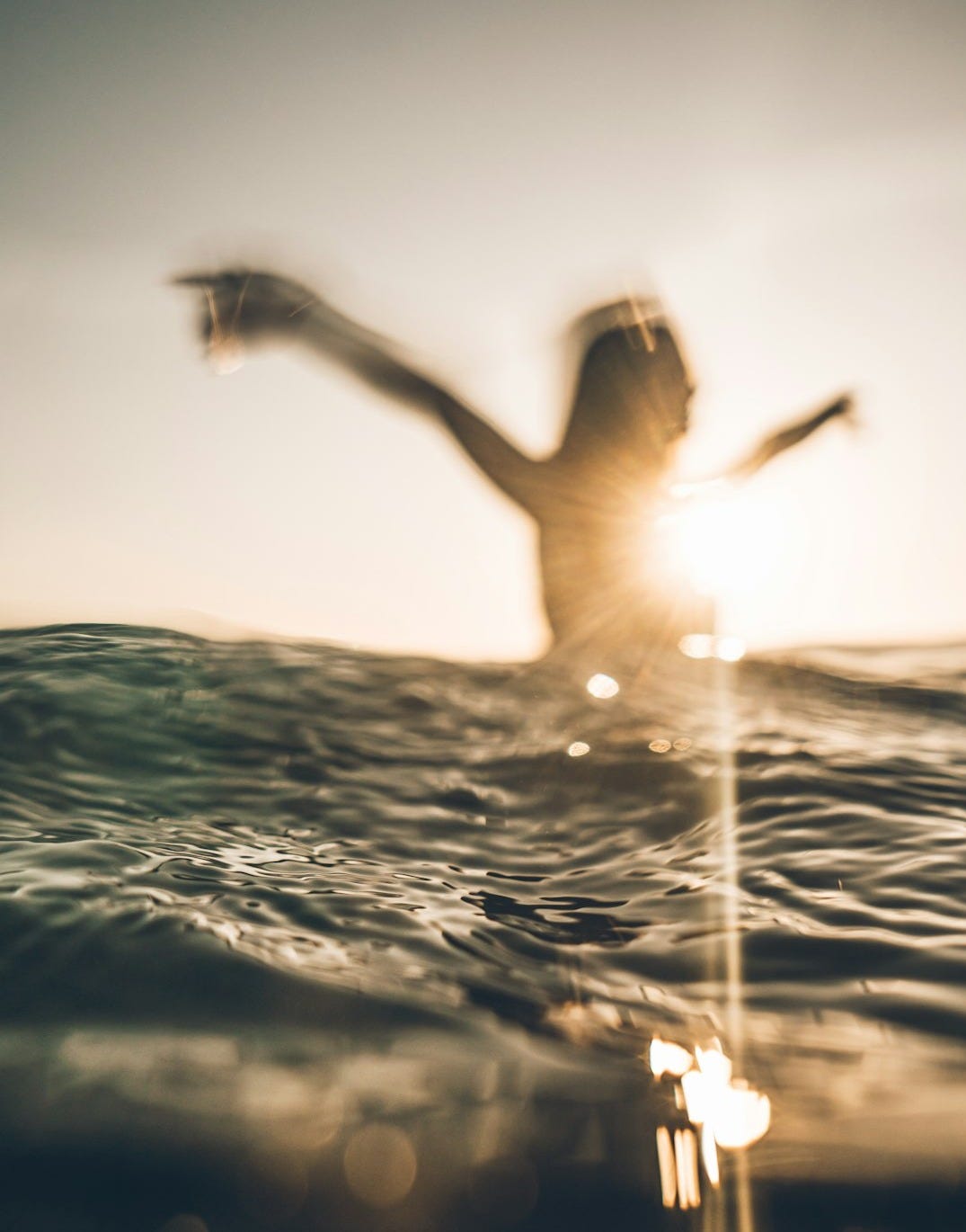 person opening her arms on sea water