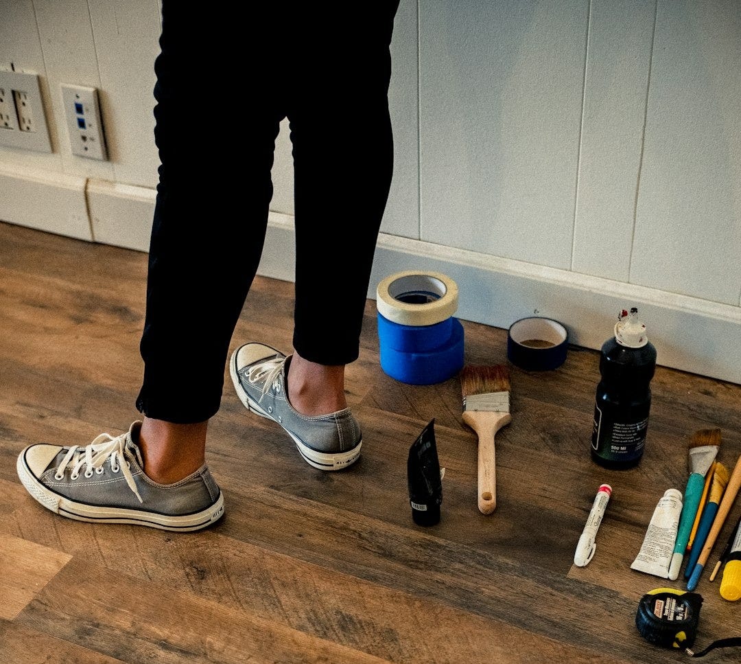 person in black pants and white and black nike sneakers standing on brown wooden floor person in black pants and white and black nike sneakers standing on brown wooden floor