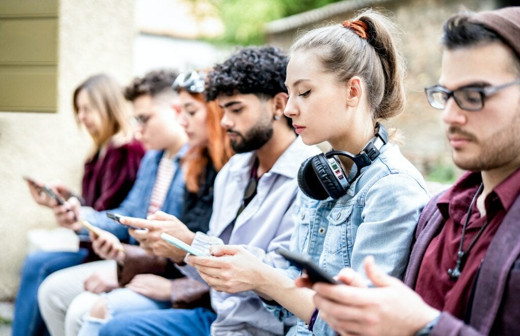 Side view of milenial men and women using smartphone devices