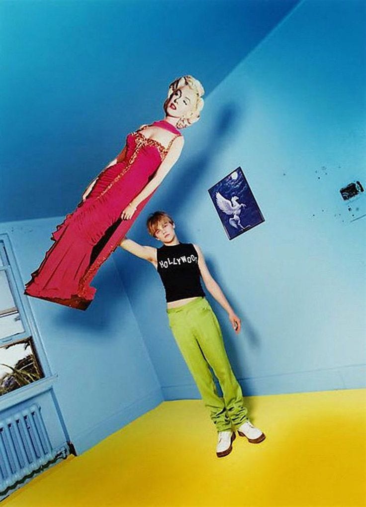 This may contain: two people are standing in a room with blue walls and yellow flooring, one person is balancing on top of the woman's head
