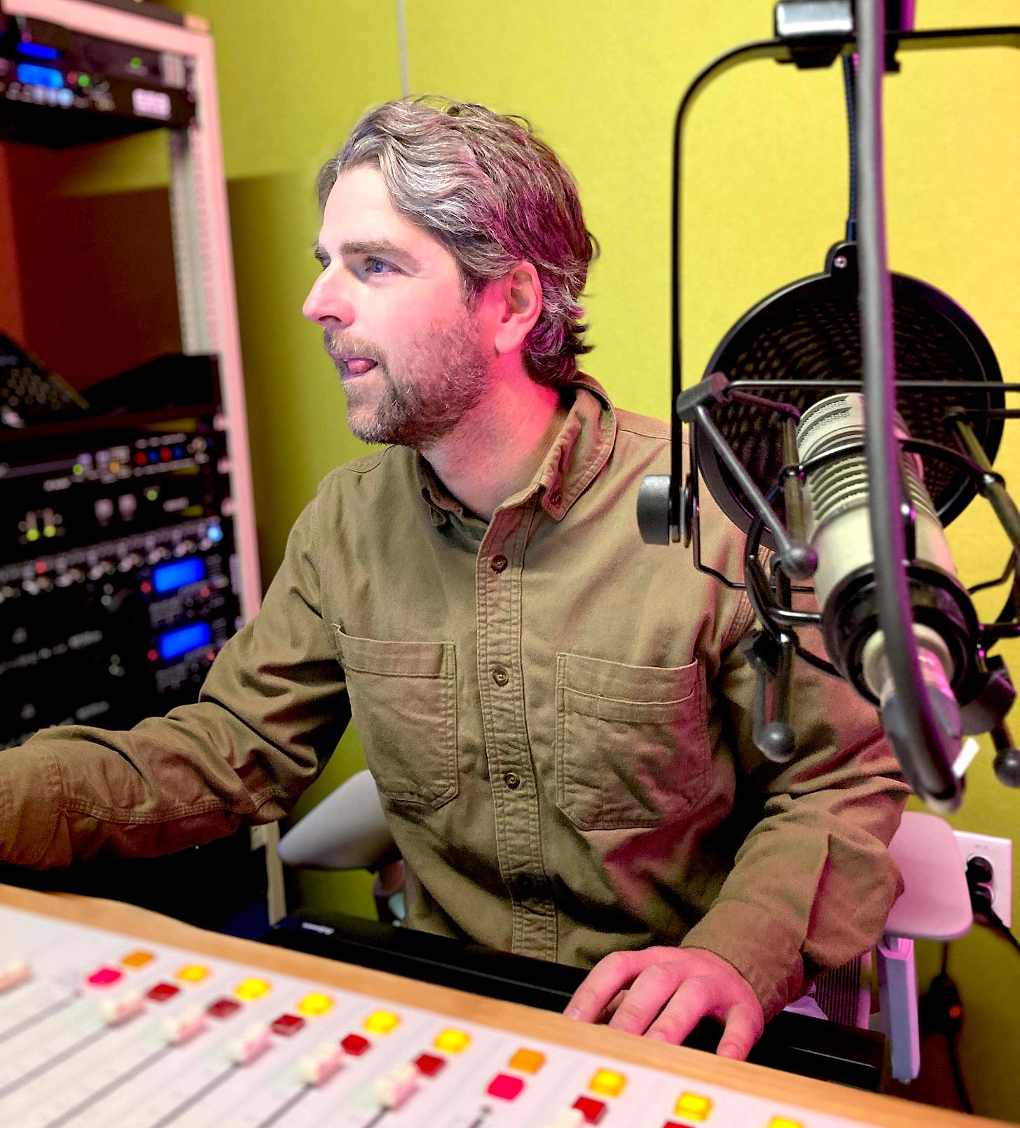 man in radio booth selects a song