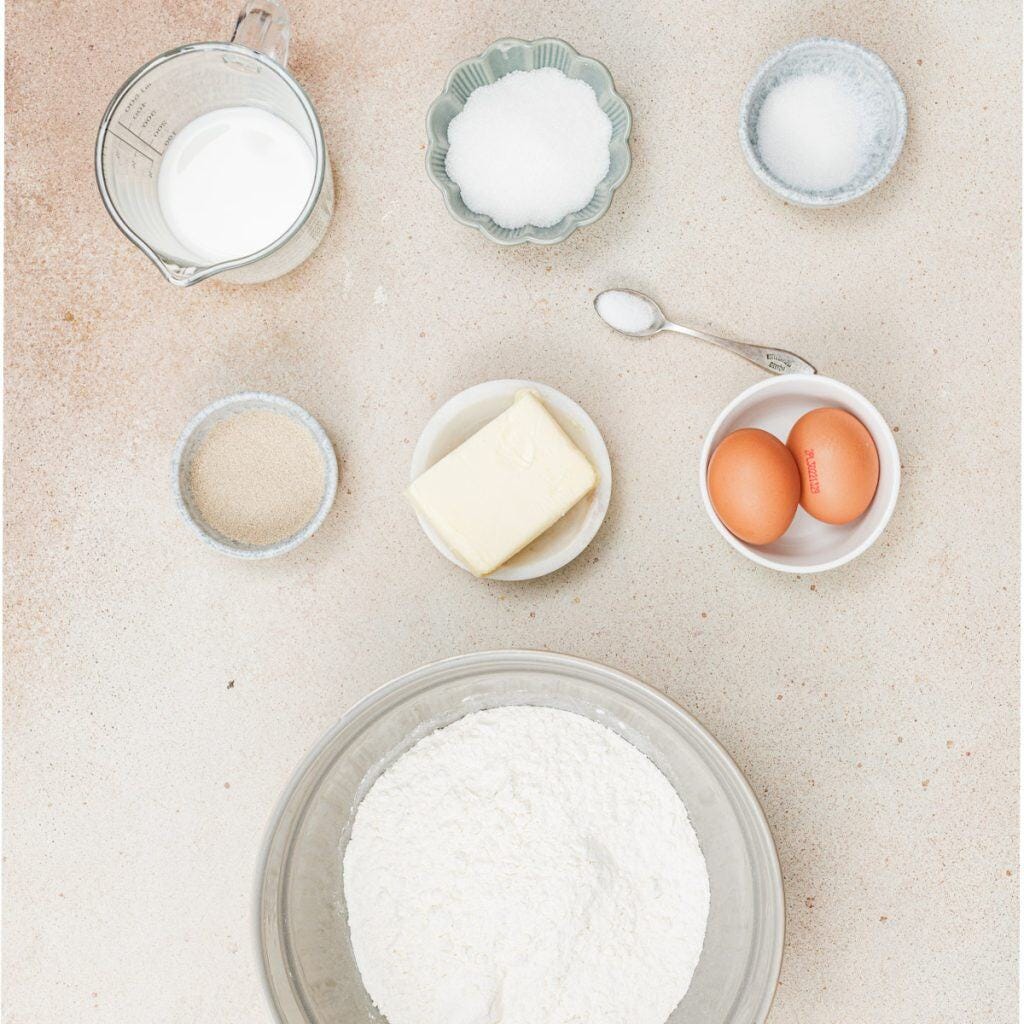 Milk, sugar, butter, eggs, salt, yeast,and vanilla in bowls.