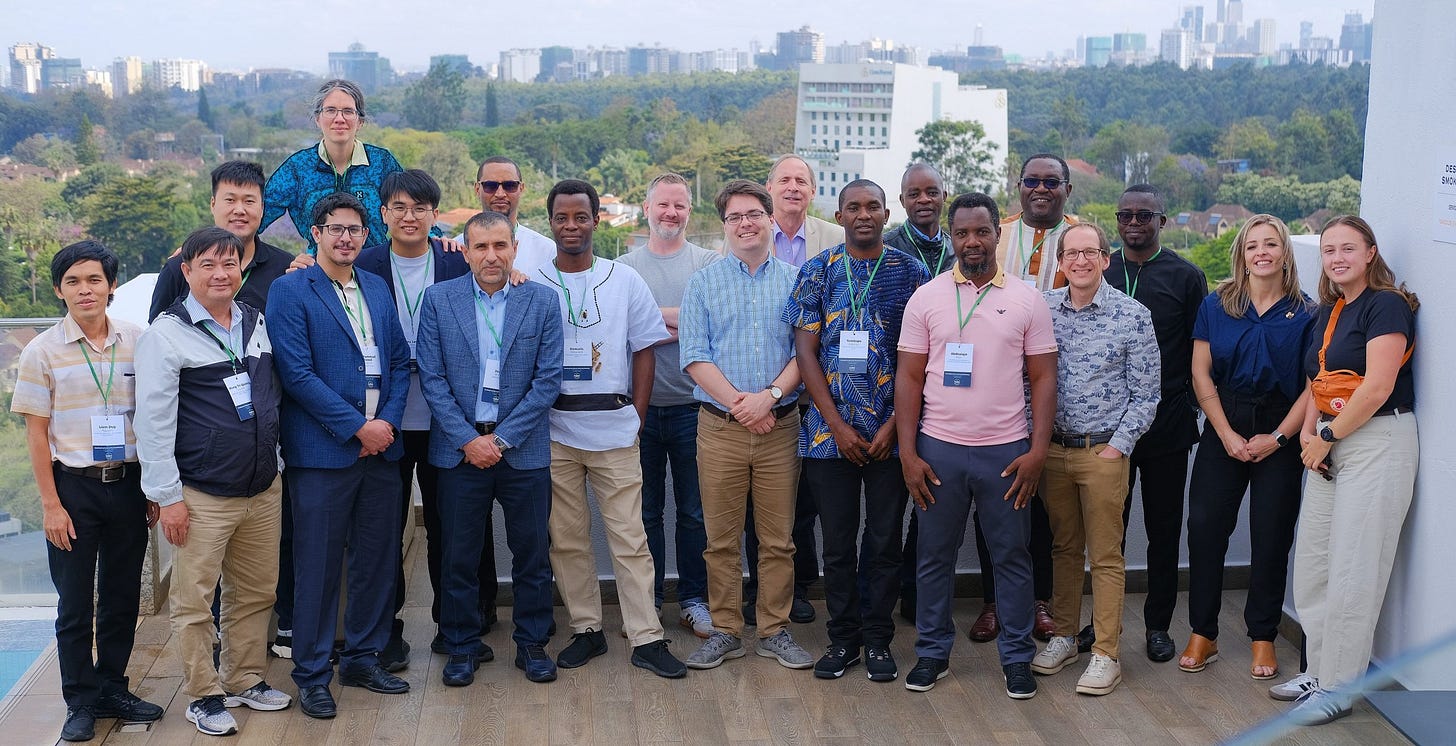 A group of people on a roof terrace, a city and a forest behind them A group of people on a roof terrace, a city and a forest behind them