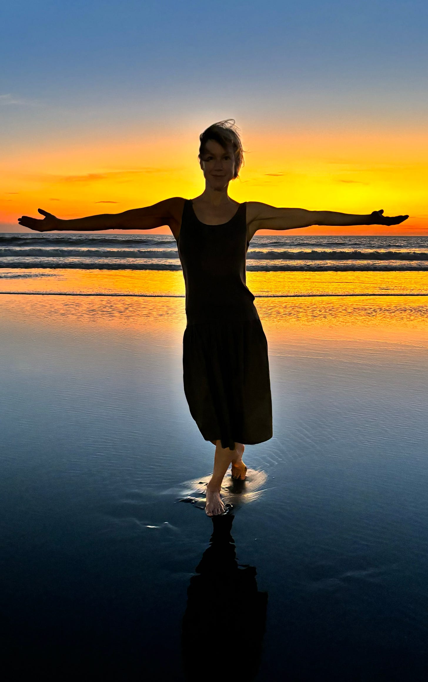 The author on the beach with a glorious sunset background