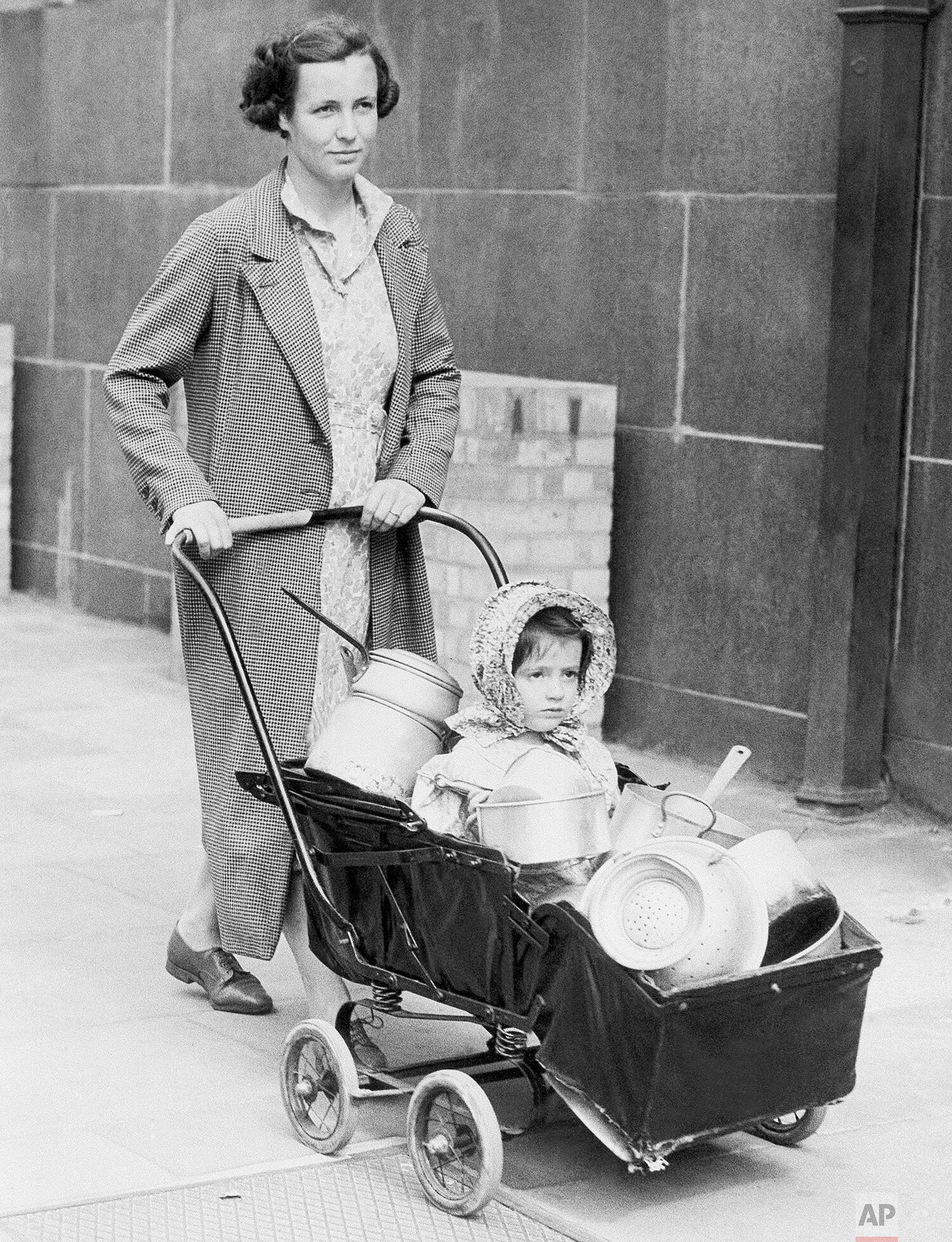 A London housewife and her child contribute aluminum pots and pans to Chelsea Town Hall on October 7, 1940, part of a national appeal to salvage materials for building Spitfire and Hurricane aircraft. A London housewife and her child contribute aluminum pots and pans to Chelsea Town Hall on October 7, 1940, part of a national appeal to salvage materials for building Spitfire and Hurricane aircraft.