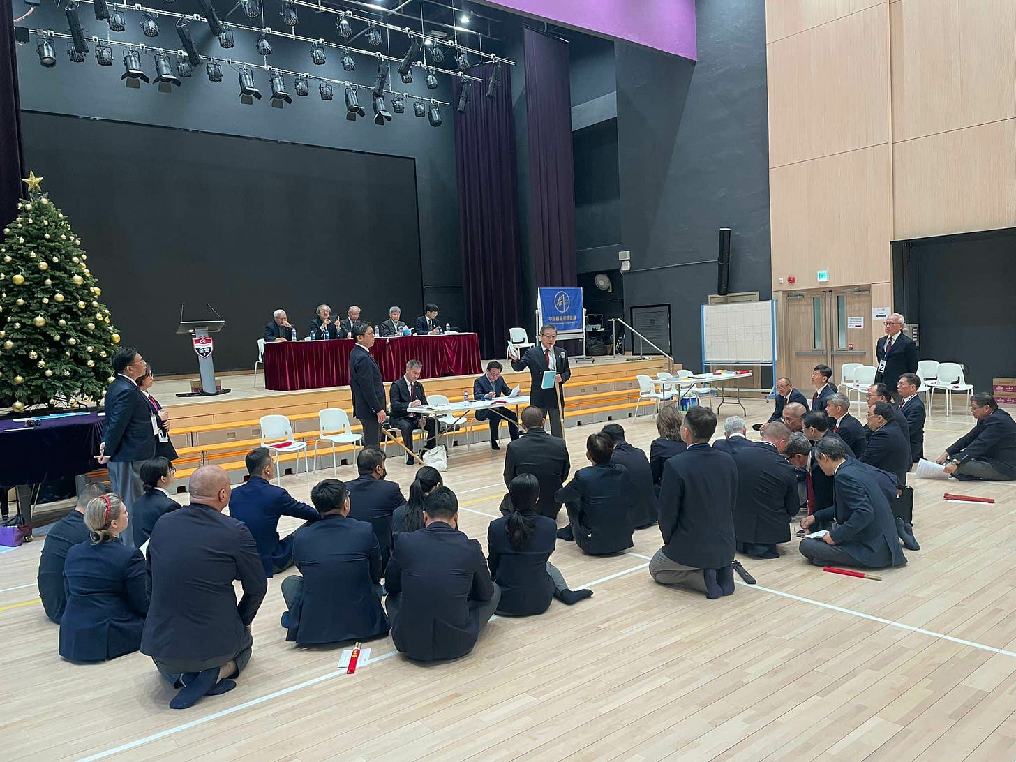 A group of people sitting on the floor

AI-generated content may be incorrect.