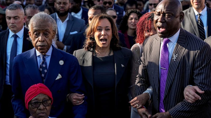 The Rev. Al Sharpton, Vice President Kamala Harris and Attorney Ben Crump walk and sing across...