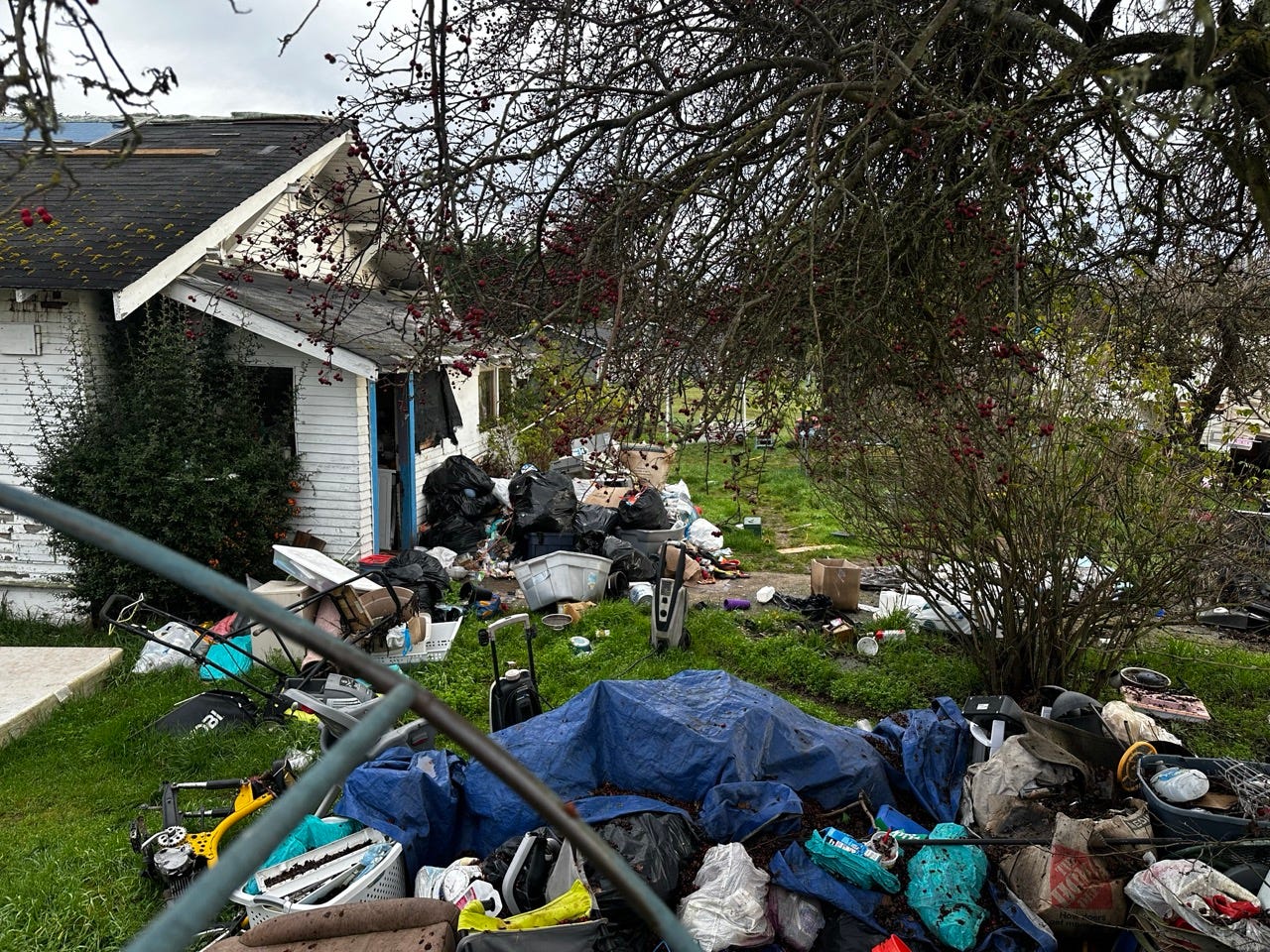 A pile of garbage in a yard

Description automatically generated