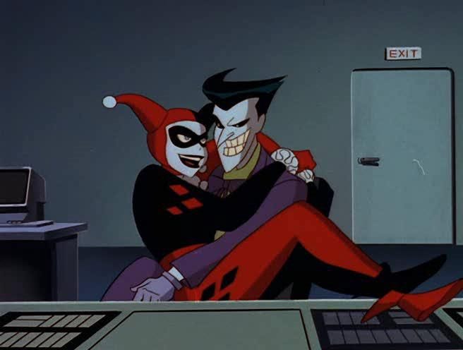 This may contain: the joker and harley hugging each other in front of a computer