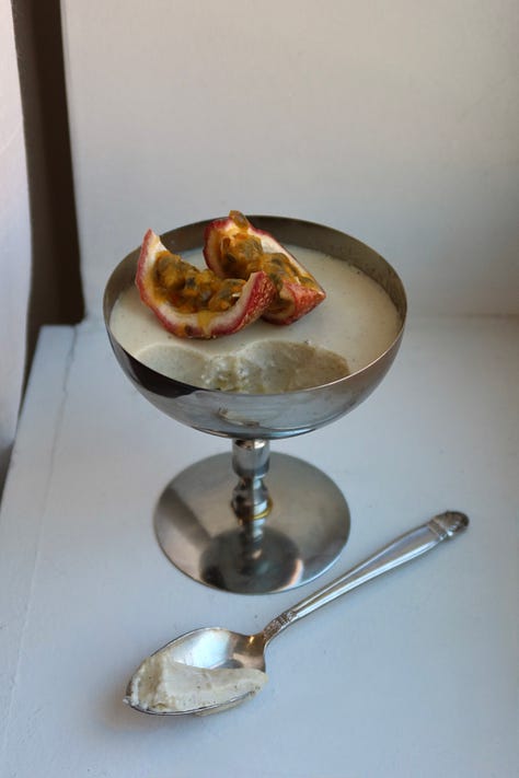 vanilla bean panna cotta in silver coupe glass with passion fruit on top 