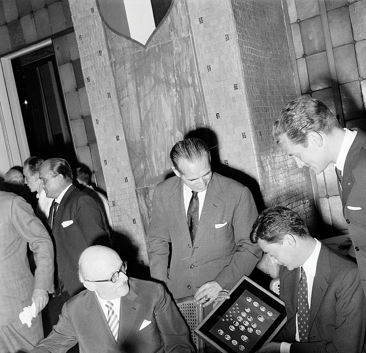 Umberto Agnelli with Juventus officials at a 1950s banquet featuring club crests and commemorative presentations.