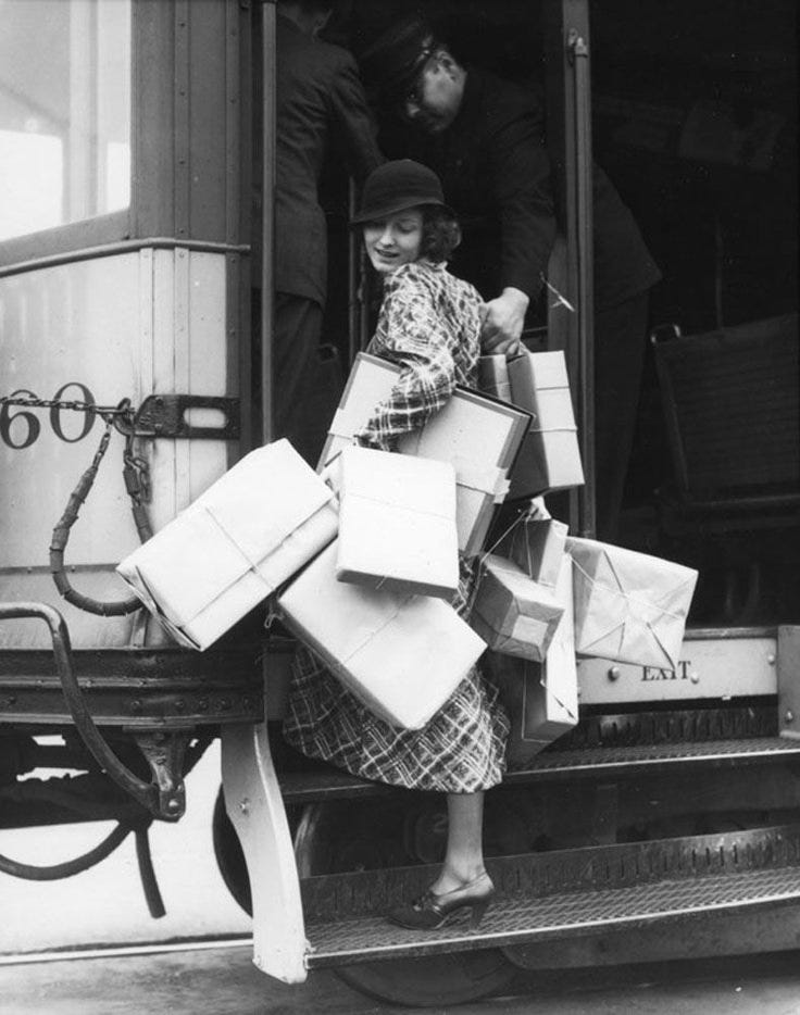 This may contain: an old black and white photo of a woman with many bags on the back of a train