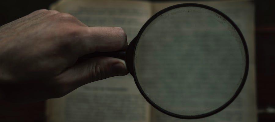 Reading book with magnifying glass