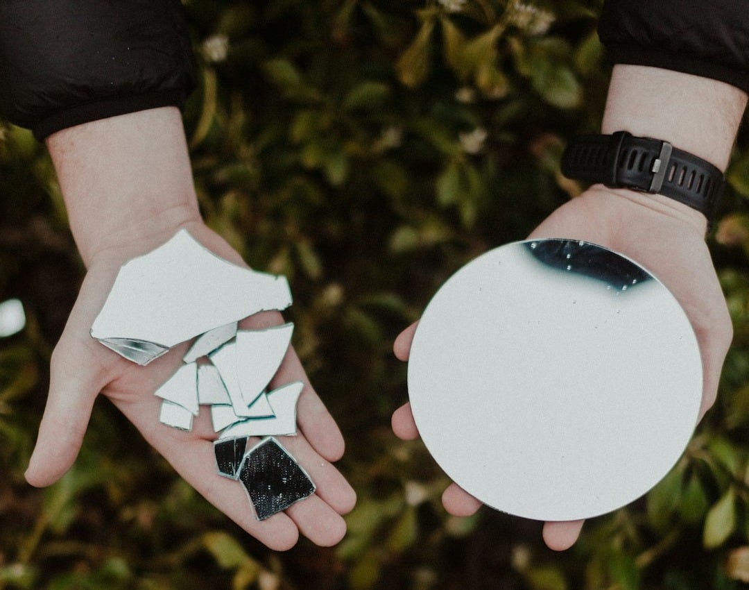 person holding round mirror