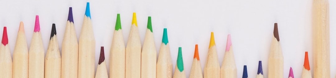 colored pencil lined up on top of white surface