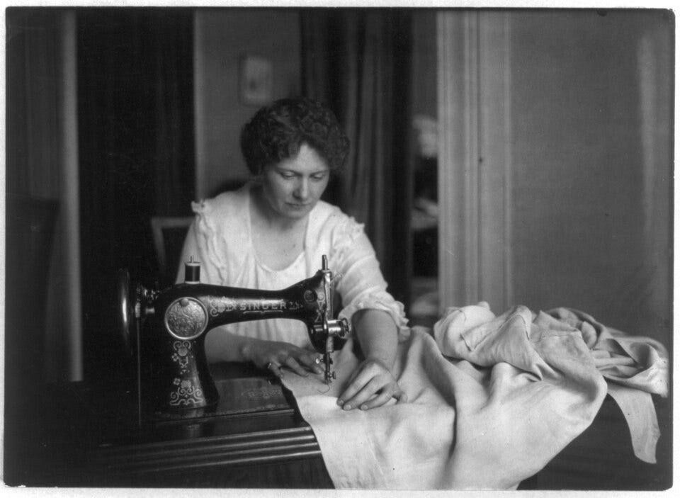Black and white image of a woman sewing with a Singer sewing machine Black and white image of a woman sewing with a Singer sewing machine