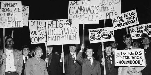 A group of protesters demonstrate holding placards against Communist sympathizers outside the Fox Wilshire Theatre in occasion of the premiere of film 'Exodus', which marked the end of the 'Hollywood Blacklist' when screen player Dalton Trumbo, a Communist Party member from 1943 to 1948 and member of the Hollywood Ten, was credited as the screenwriter of the film, Beverly Hills, Los Angeles, California, US, December 1960. (Photo by American Stock Archive/Archive Photos/Getty Images)