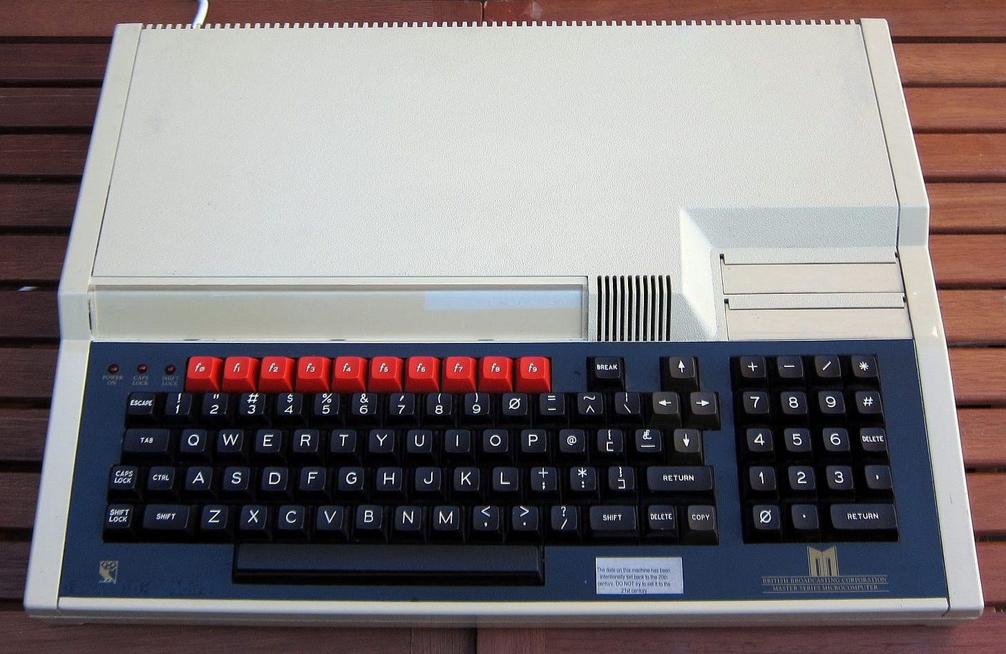 A BBC Master 128 computer on a wooden table. 