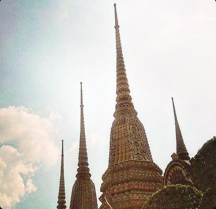 Glimmering gold turrets rise into the blue skies of Bankok and diners relax at sunset with a neon sky overlooking the Chao Phraya River.view of