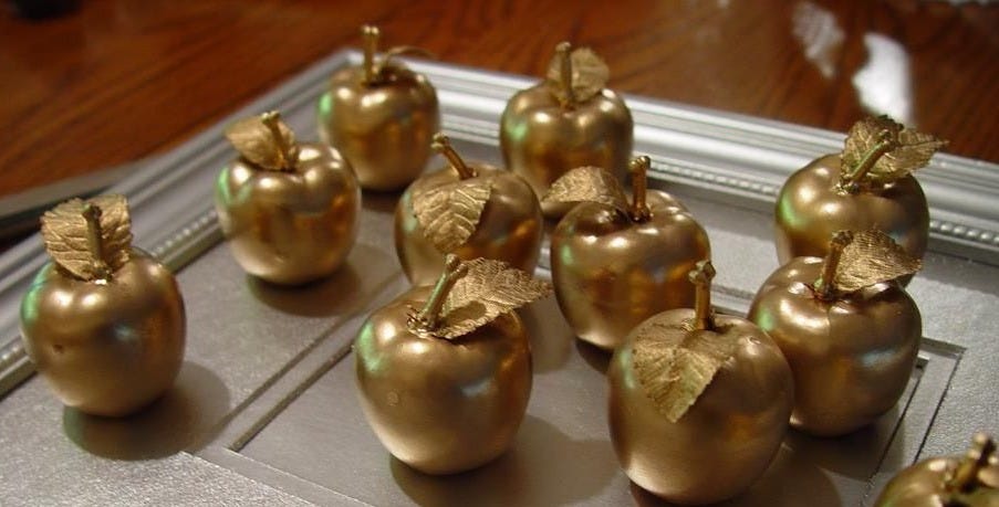 there are many golden apples on the tray